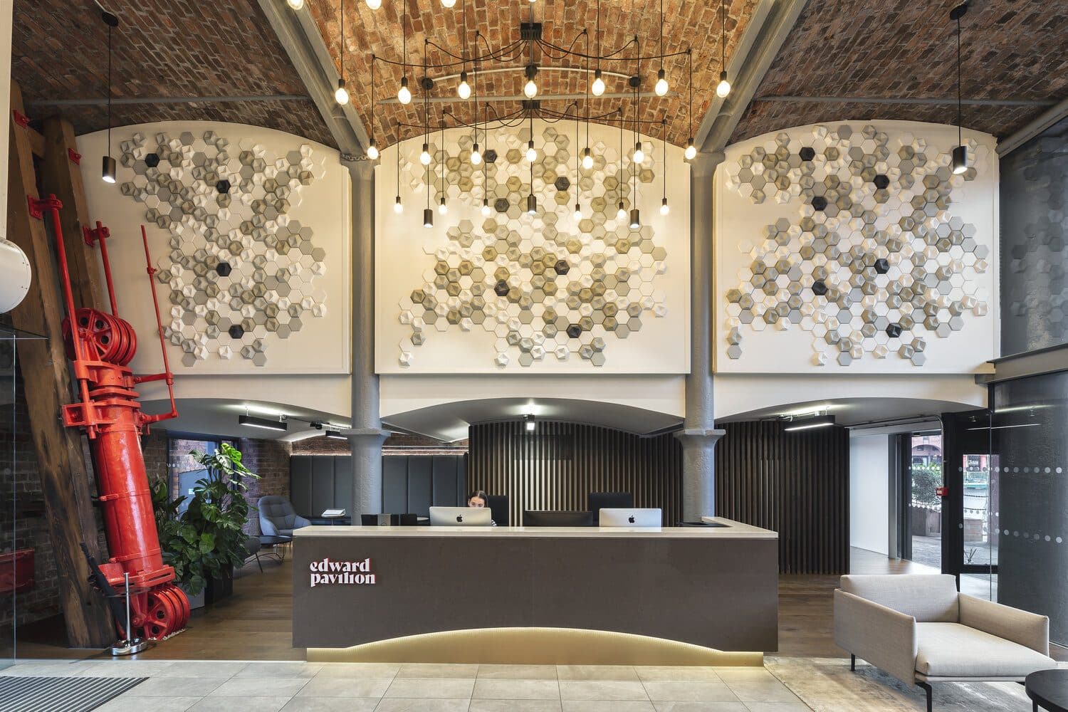 A reception desk under brick vaults in a warehouse conversion