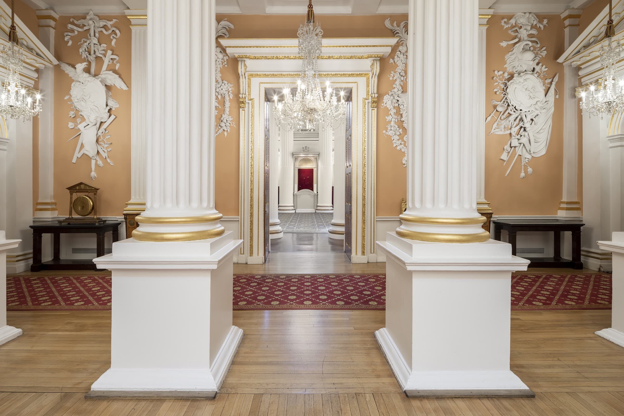 A grand columned anteroom with chandeliers, photographed by Biztour