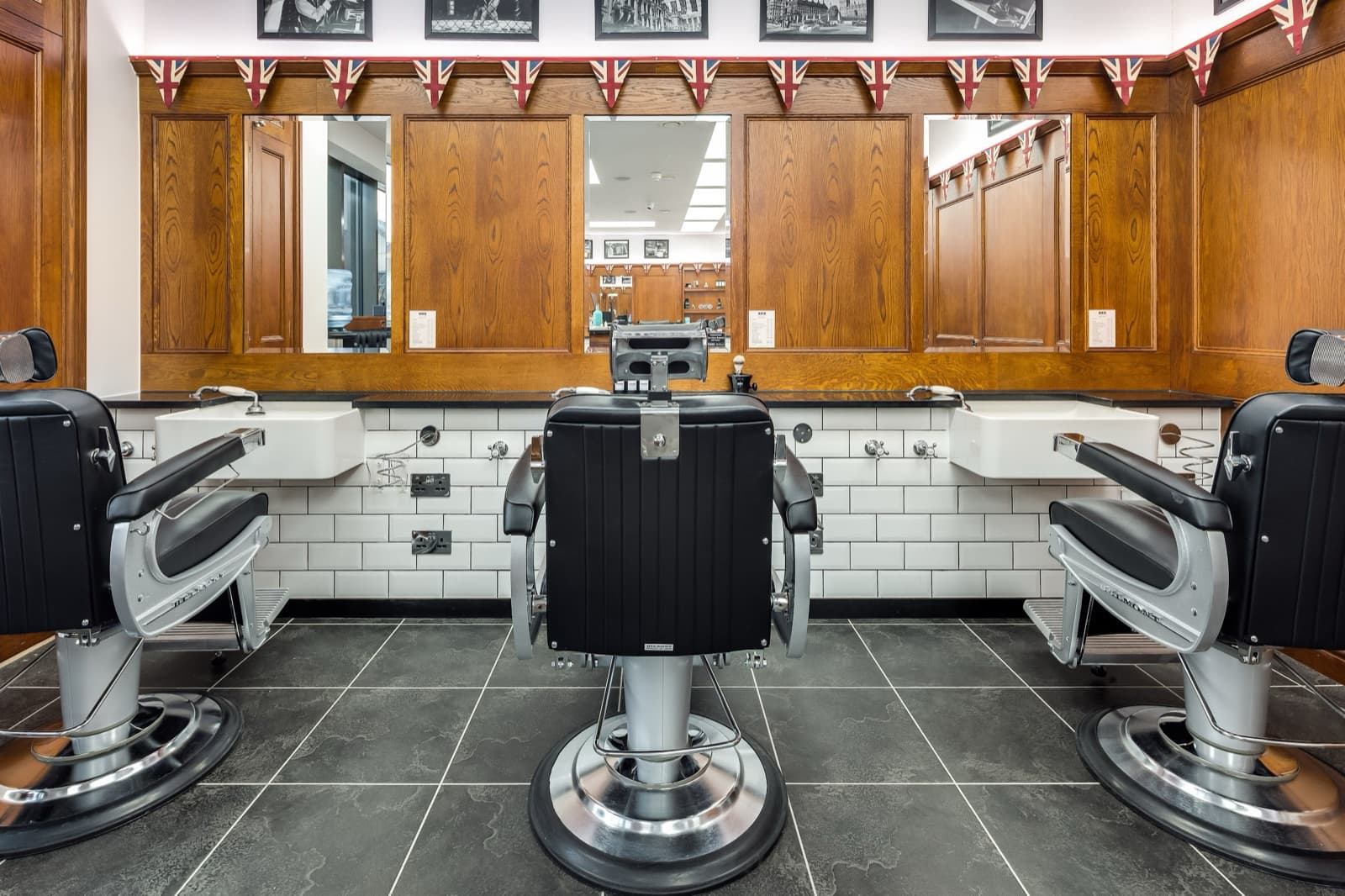 The barber chairs and tiled wash stations at Pall Mall Barbers, King's Cross