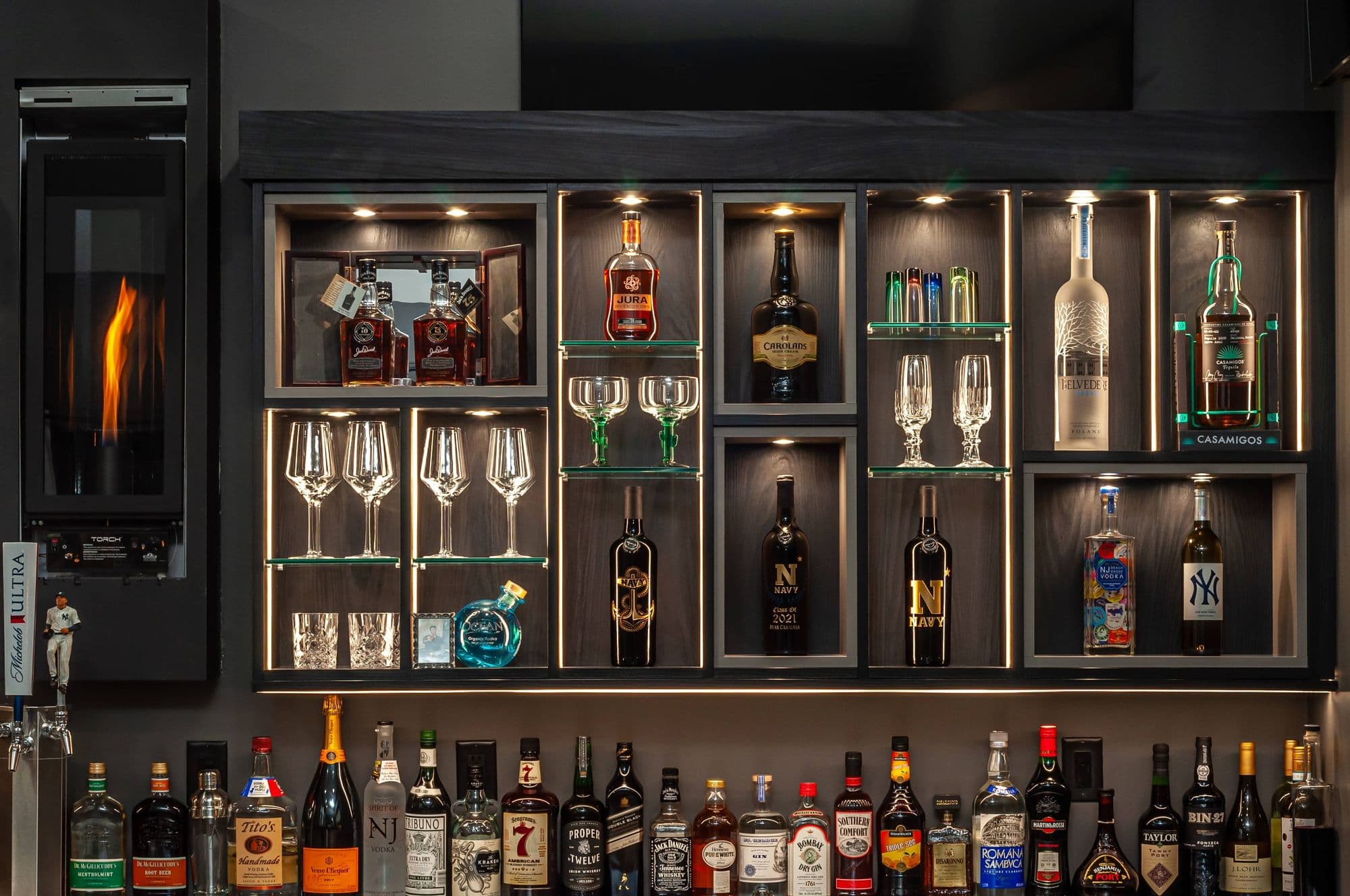 Backlit bar shelves stocked with spirits and glassware