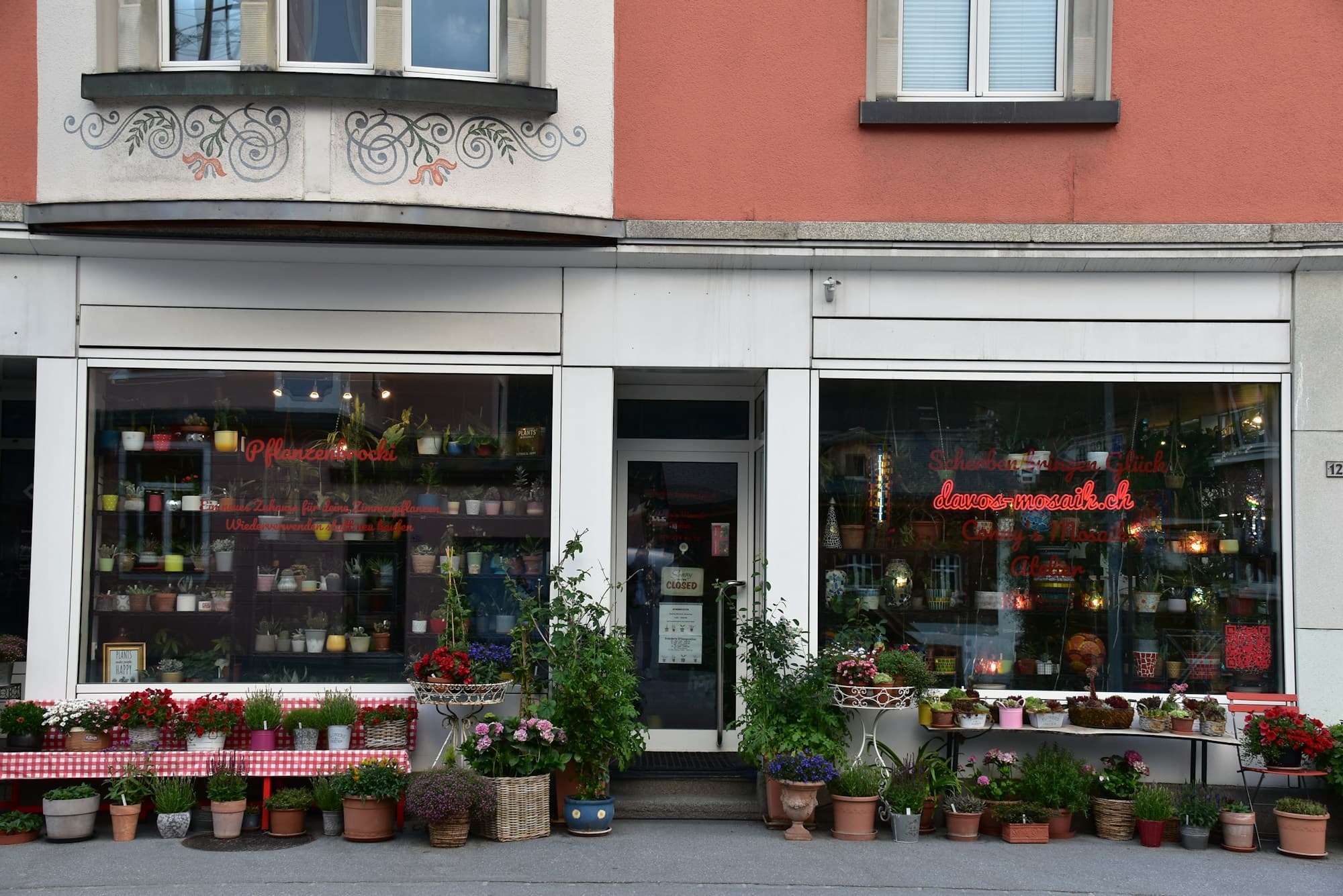 A plant shop storefront with potted plants displayed outside