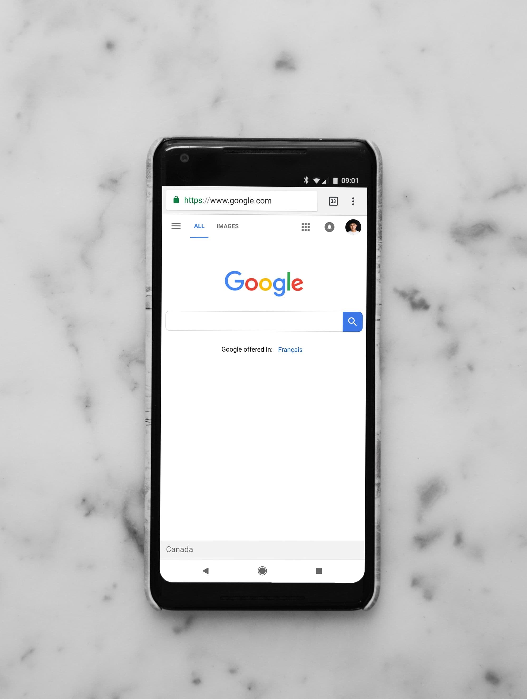 A smartphone showing the Google search page on a marble surface